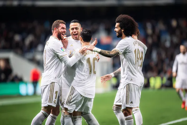 REAL MADRID লাইভ ক্যাসিনো - যোগ দিন বাস্তব ডিলারের রোমাঞ্চকর টেবিলে টাক্সেডো পরা একজন প্রফেশনাল ডিলার রুলেট টেবিলে খেলোয়াড়দের স্বাগত জানাচ্ছেন-যা REAL MADRID–এর আসল লাইভ ক্যাসিনো অনুভূতিকে প্রকাশ করে।